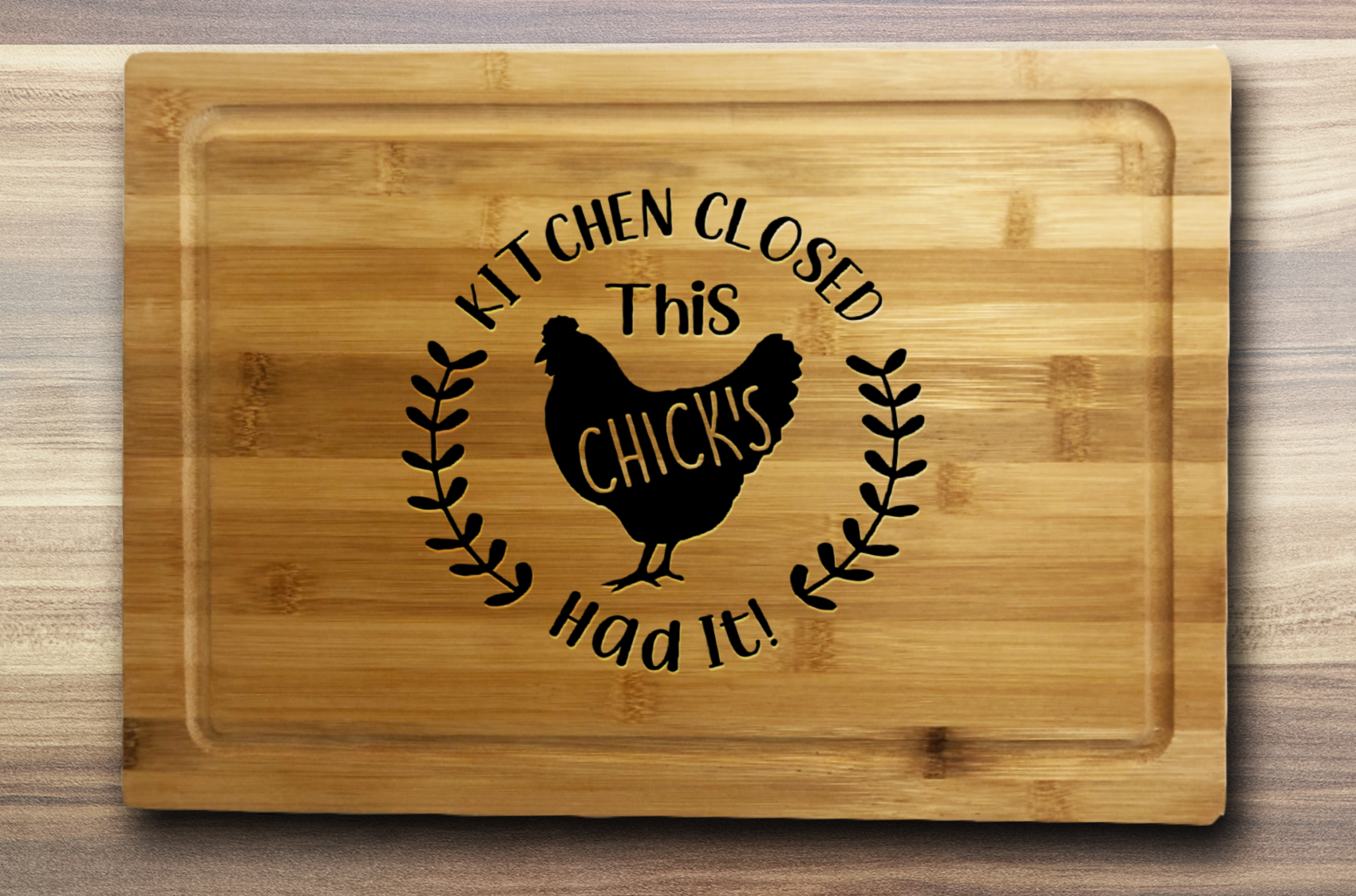 A bamboo laser engraved cutting board that says kitchens closed this chicks had it