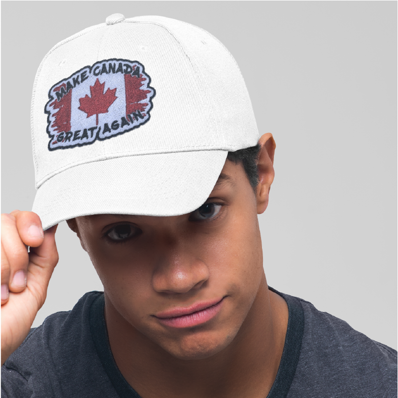 A man wearing a embroidered patch on a white hat that has a torn Canadain flag and says make Canada great again