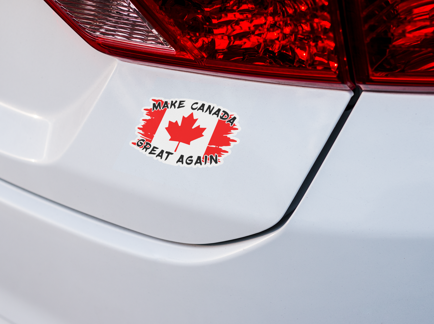 a sticker with the Canadian flag torn with the saying make Canada great again on the back of a car