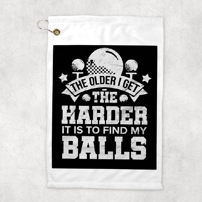 A 12x18inch white golf towel with the saying the older I get the harder it is to find my balls